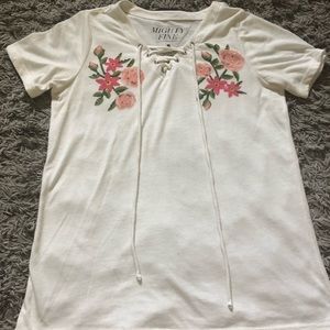 A white floral lace up t-shirt 🌸.